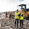 a man and woman standing in front of a dump