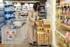 a woman in a suit standing by a cart with food in a store