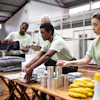 a group of people in green shirts packing food