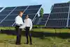 men standing in a field with solar panels