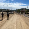 a couple of people walking on a dirt road
