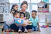 a woman reading a book to children