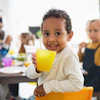 a child holding a yellow cup