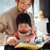 a woman and a baby reading a book