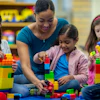 a woman and children playing with blocks