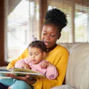 a woman reading a book to a baby
