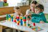 a woman and kids playing with blocks
