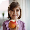 a girl holding an apple