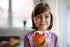 a girl holding an apple