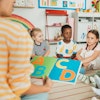 a group of children sitting on the floor in a classroom