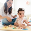 a woman and baby playing with a game