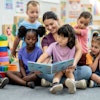 a group of children reading a book