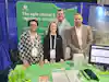 a group of people standing in front of a green table