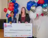 a woman and boy holding a check