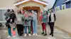 a group of people standing in front of a house