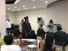 a group of people in a room with a cameraman