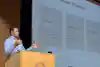 a man standing at a podium giving a presentation