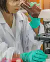 a girl looking through a microscope
