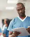 a man in blue scrubs holding a clipboard