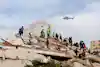 CARABALLEDA, VENEZUELA - JUNE 28: Rescuers search for victims at a collapsed building as a helicopter flies by in the background following a magnitude 7.2 earthquake that struck Venezuela and other regions in the Caribbean, on June 28, 2026 in Caraballeda, La Guaira, Venezuela. According to the U.S. Geological Survey (USGS), the main earthquake on June 24, 2026 was followed by a 7.5-magnitude aftershock less than a minute later. The number of fatal victims increased to more than 1000, while the number of injured people exceeded 3,000. More than 70,000 people are reported missing. (Photo by Jesus Vargas/Getty Images)