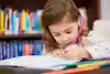 a girl writing on a book