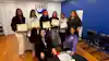 a group of women holding certificates