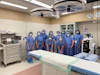 a group of people wearing surgical masks and scrubs standing in a room