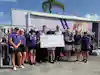a group of people holding a large check