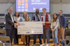 a group of people holding a large check