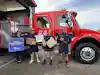 a group of people standing in front of a red truck
